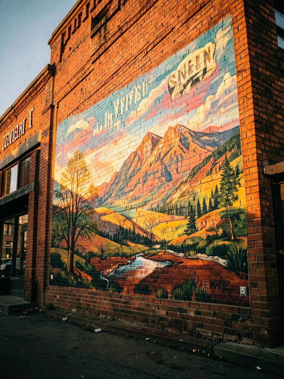 Painted landscape mural on a downtown brick building in Western Colorado